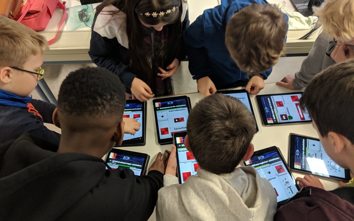 Eine Gruppe von Kindern spielen das Spiel Spacteam an verschiedenen Tablets im Rahmen einer Studie