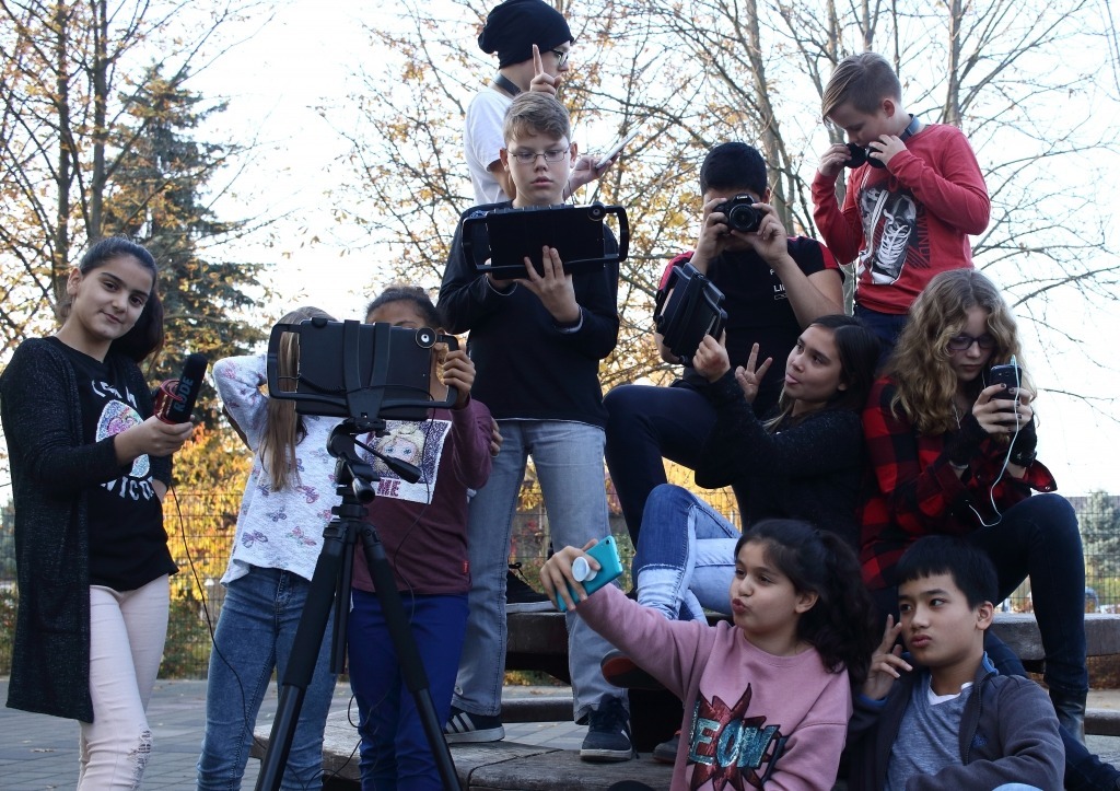 Eine Gruppe von Kinder machen Selfies, machen Fotos mit ihren Smartphones oder mit ihrer Kamera Smartphones oder ihrer Kamera oder