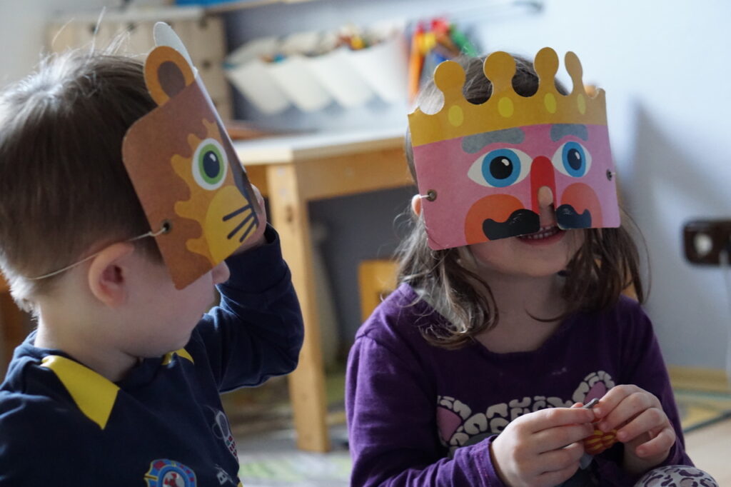 Ein kleines Kind und ein kleines Mädchen im Kindergarten mit einer Gesichtsmaske.