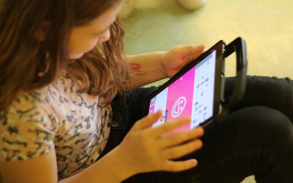 Ein kleines Mädchen zeichnet auf einem Tablet.