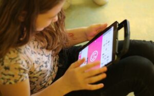 Ein kleines Mädchen zeichnet auf einem Tablet.