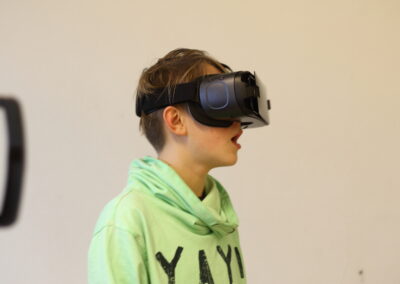 Ein Junge trägt eine Virtual-Reality-Brille und er sieht überrascht aus