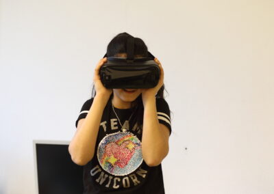 Ein Mädchen trägt eine Virtual-Reality-Brille und sie lacht dabei.