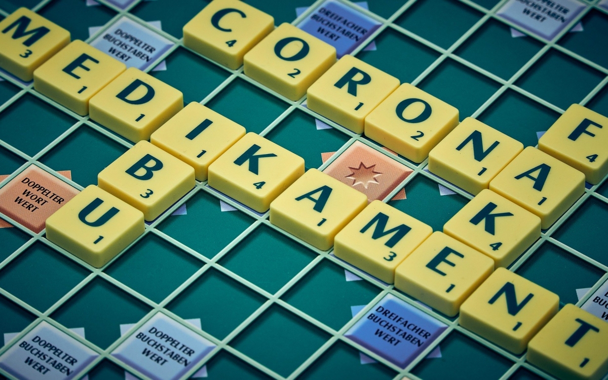 Ein Scrabblebrett mit den Wörtern "Corona" "Fake" und "Medikament"