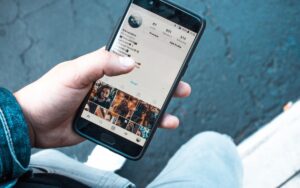 Eine Hand hält ein Smartphone. Auf dem Display des Smartphones ist die Seite eines Instagramkontos zu sehen.