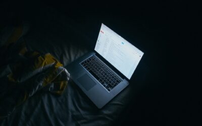Ein Notebook in einem dunklen Raum. Das Display zeigt die E-Mail-Seite an.