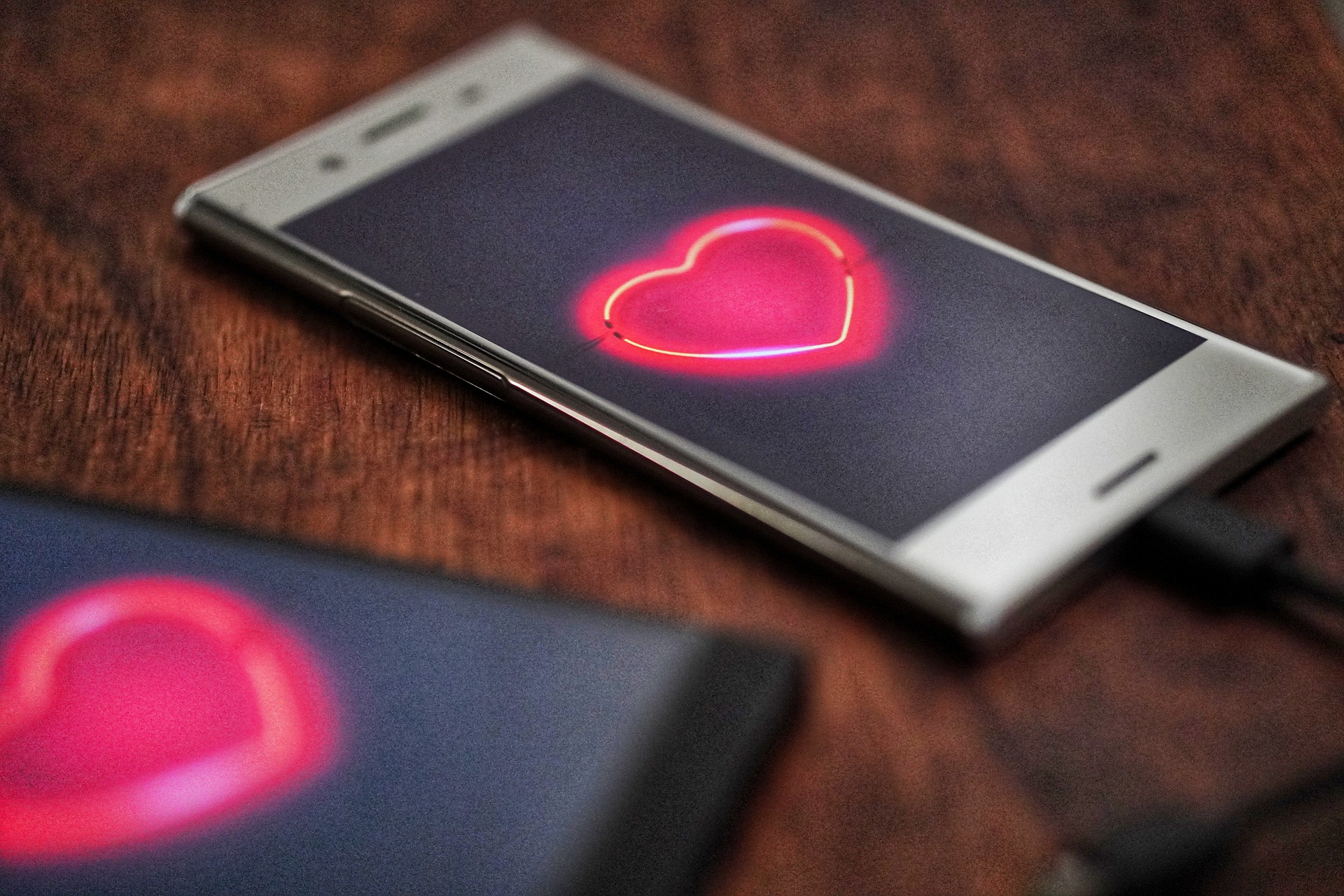 Ein Smartphone-Display mit einem roten Herz und einem schwarzen Hintergrund.
