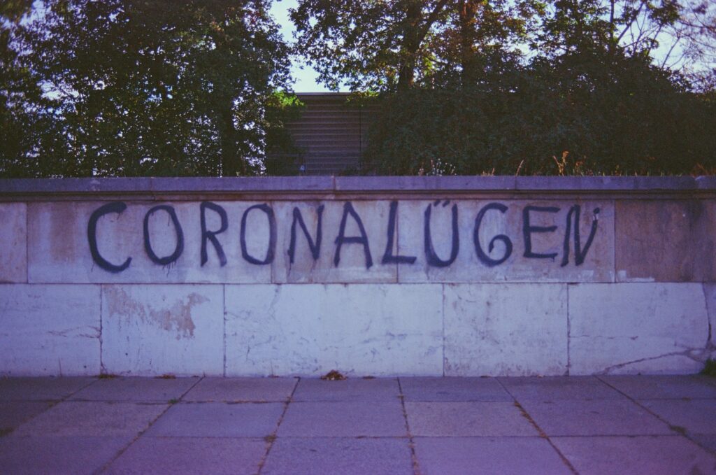 Eine Mauer auf der mt Grafitti das Wort "Coronalügen" drauf gesprüt wurde.