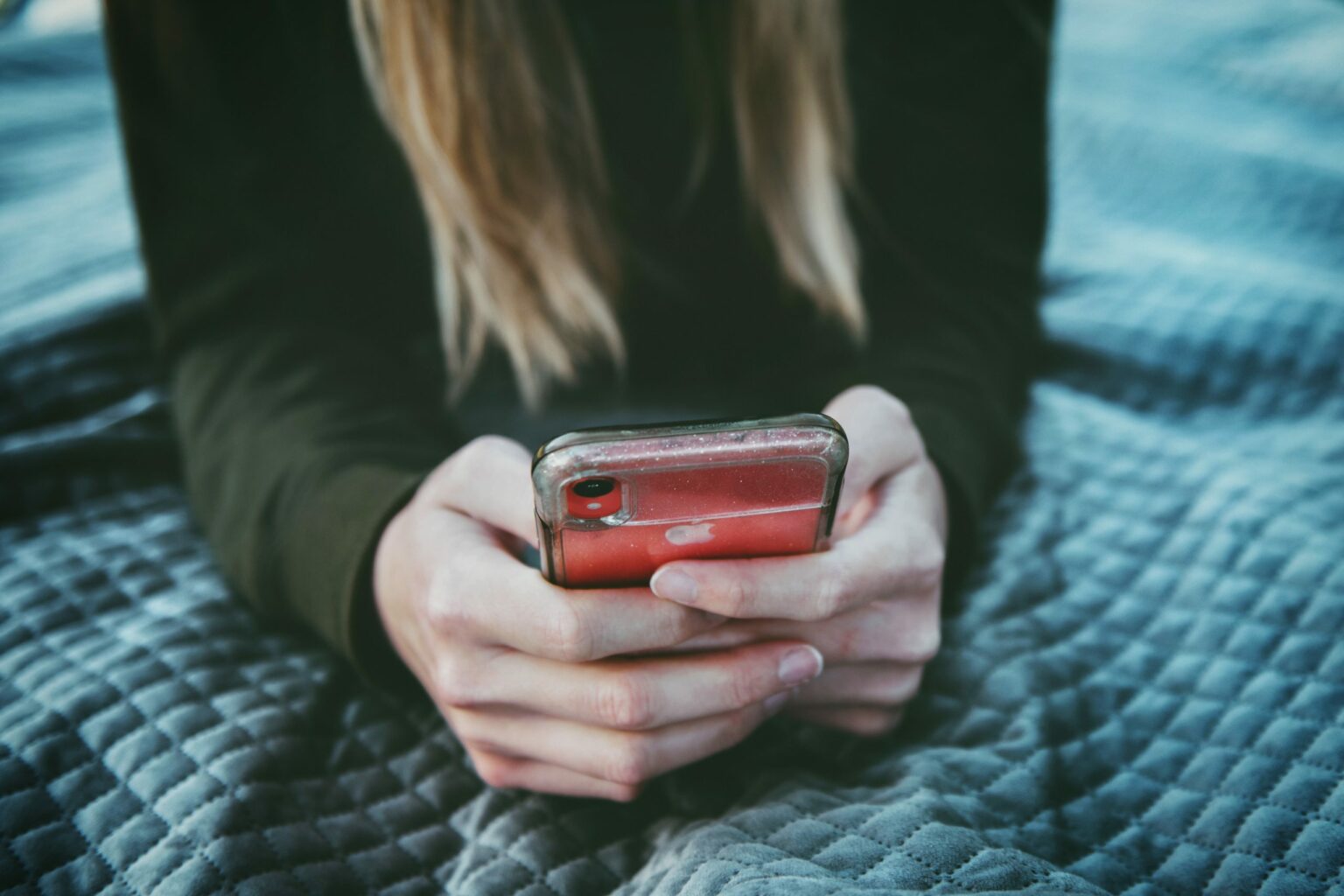 Eine Person hält ein Iphone in den Händen.