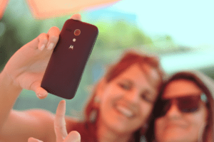 Zwei junge Frauen machen ein Selfie mit einem Handy der Marke Motorola.