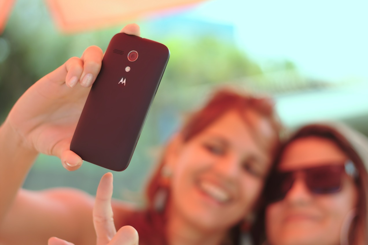 Zwei junge Frauen machen ein Selfie mit einem Handy der Marke Motorola.