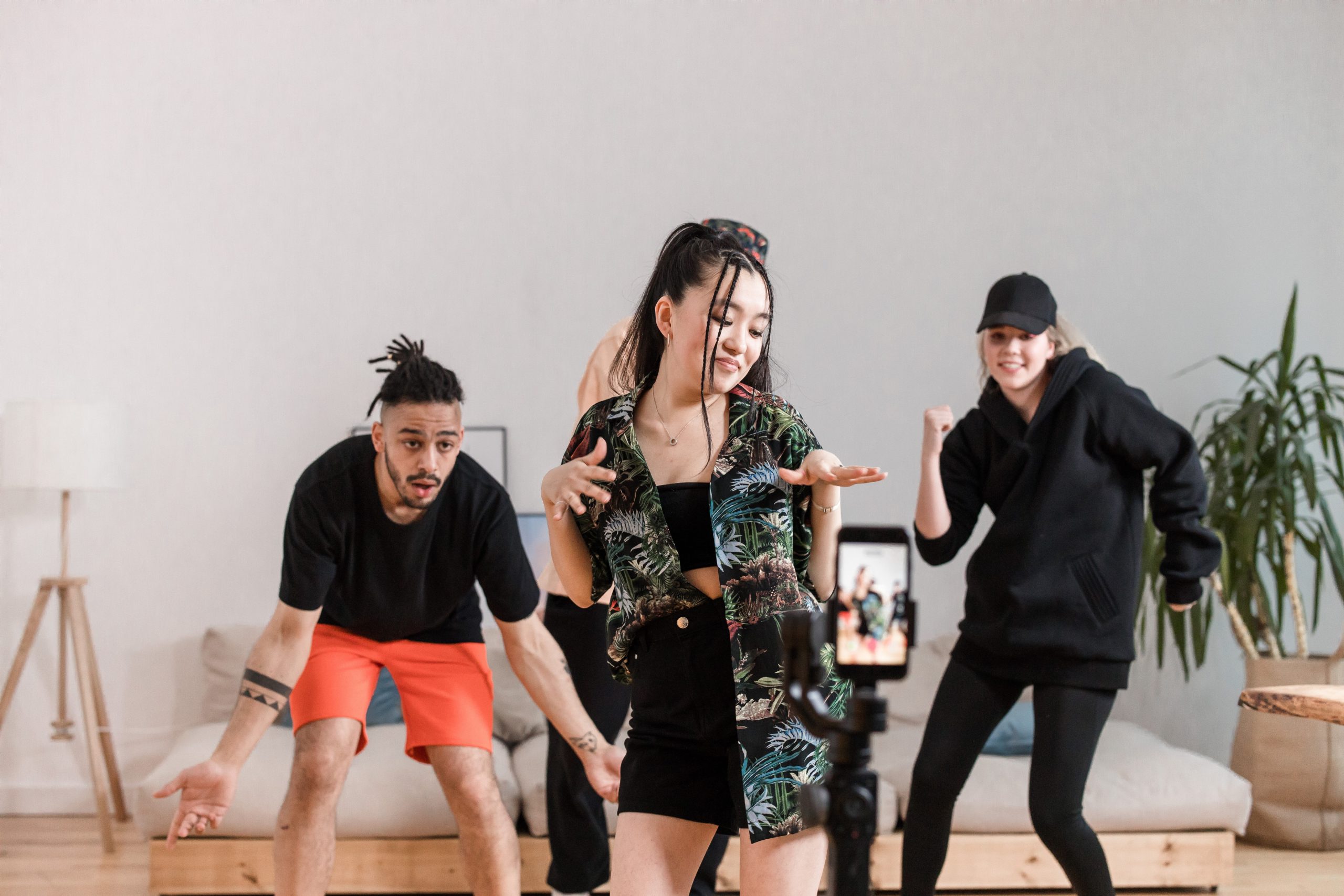 Vier Personen filmen sich selbst mit einem Smartphone beim Tanzen.