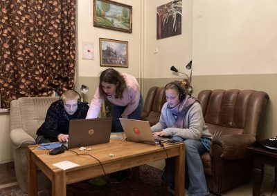 Drei Personen beugen sich über zwei Laptops