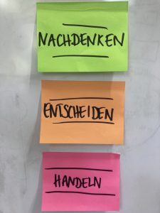 Drei farbige Post-Its mit den Worten: Nachdenken, Entscheiden, Handeln